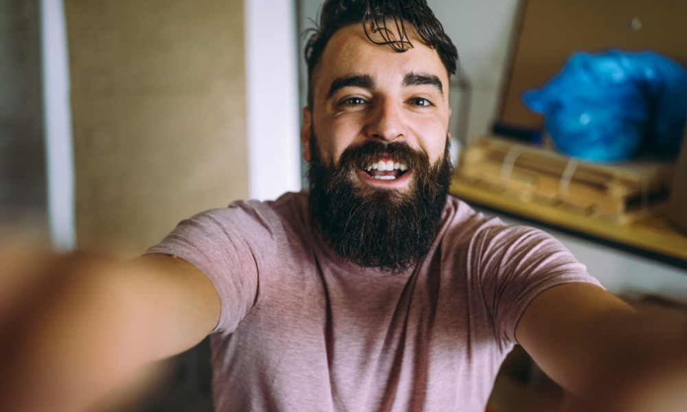 Chico sonriendo mientras se hace un selfie